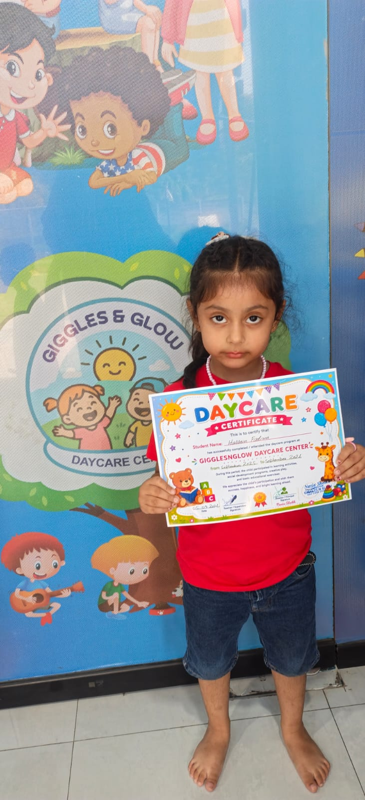 A little learner proudly holding her Montessori certificate