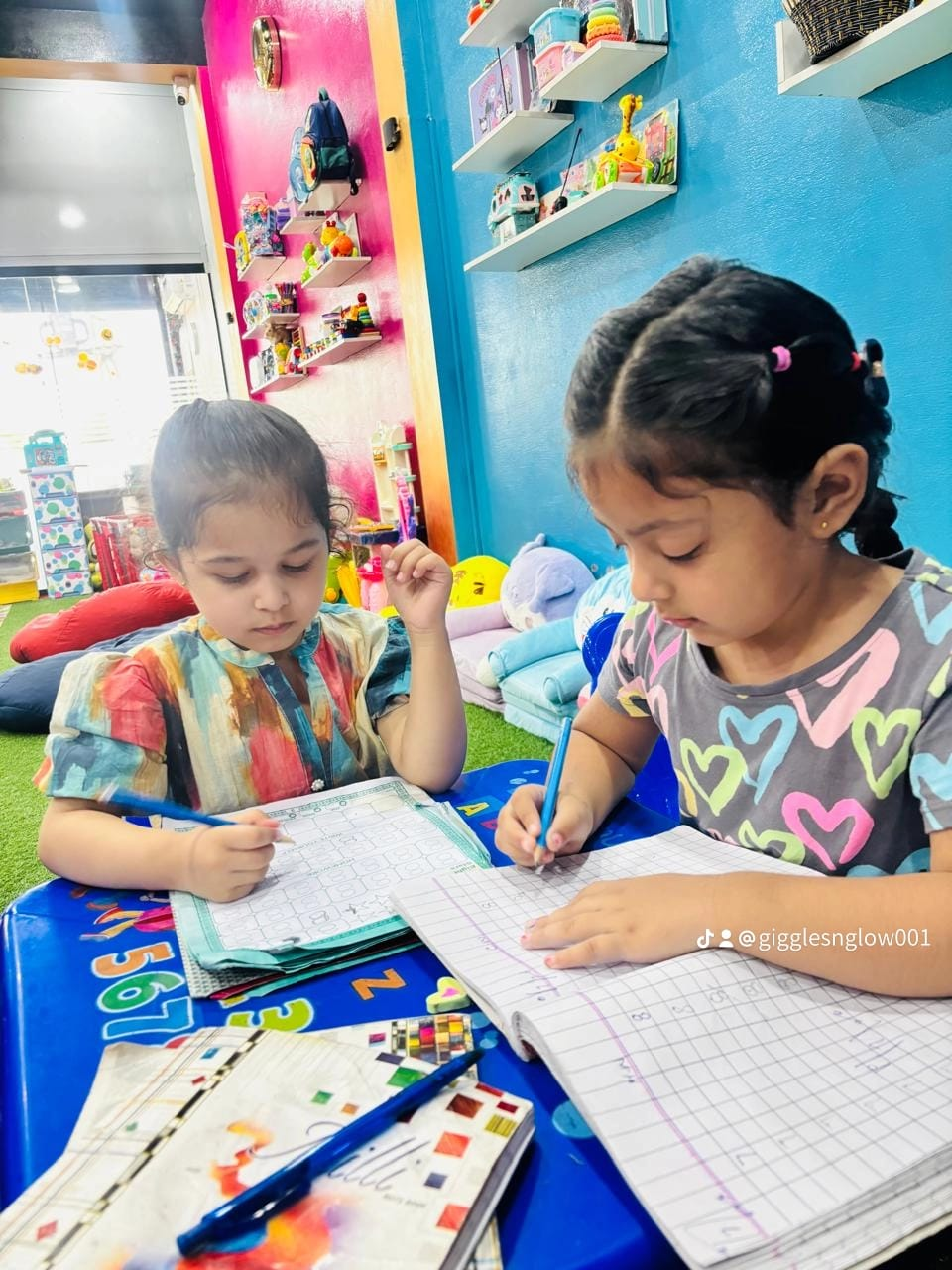 Two little learners practising writing together